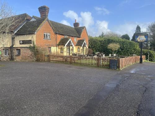 a brick house with a wooden fence in front of it at The Punchbowl Inn in Dorking