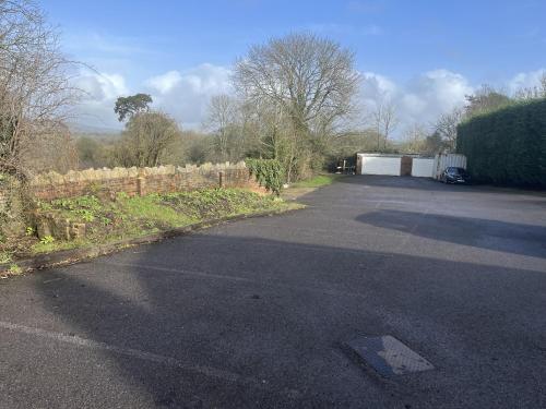 an empty parking lot with a fence and a driveway at The Punchbowl Inn in Dorking