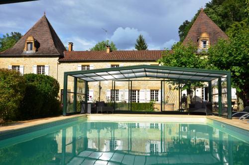 a house with a swimming pool in front of a house at Le Logis du Port in Domme