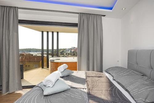 a bedroom with a bed and a large window at Villa Bellavista in Medulin