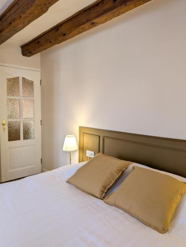 a bedroom with a white bed with a wooden headboard at Maison Mycélia in Buhl