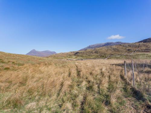 a field of grass with mountains in the background at Shepherds Hut - Uk49096 in Inchnadamph