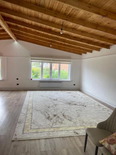 an empty living room with a rug on the floor at Guest house Sayak in Bokonbayevo