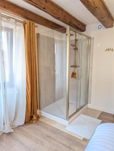 a shower in a room with a glass door at Maison Mycélia in Buhl