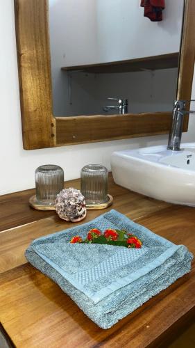 a bathroom counter with a towel and a sink at Palm House&Restaurant in Utende