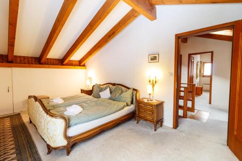 a bedroom with a large bed and a table at Ferienhaus Grundschera Engadin in Brail