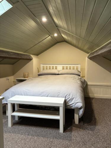 a bedroom with a large bed with a white bed frame at The old surgery in Rhymney