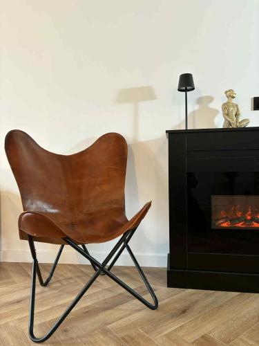 a brown chair sitting in front of a fireplace at Apartamenty Staszica in Bielsko-Biała
