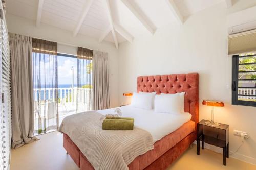 a bedroom with a large bed and a balcony at Villa El Rincon 637 - Coral Estate in Willibrordus