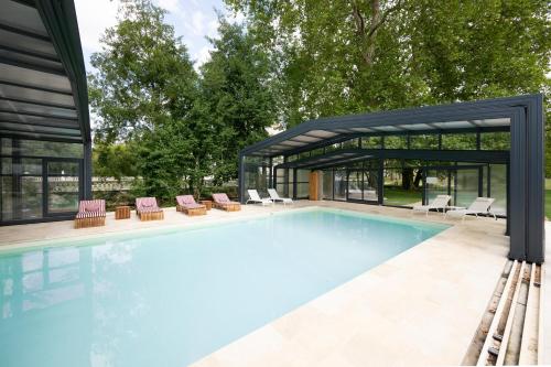 a swimming pool with chairs and a house at Château Optical Center in Nieuil