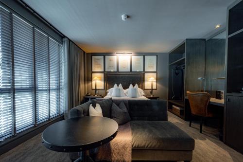 a hotel room with a bed and a couch and a table at Dakota Glasgow in Glasgow