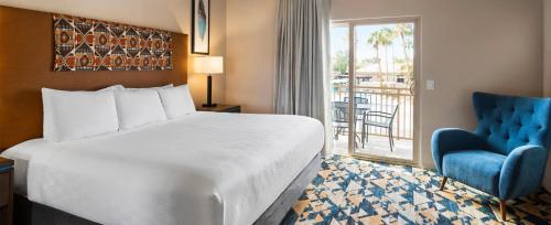 a bedroom with a bed and a chair and a window at WorldMark Scottsdale in Scottsdale