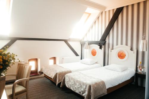 a bedroom with two beds and a table and a chair at Winnice Jaworek in Miękinia