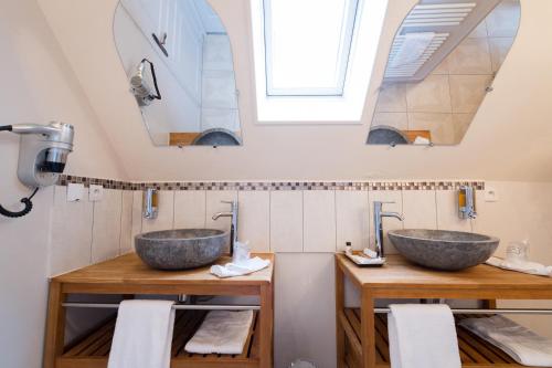 two sinks in a bathroom with two mirrors at Aux Charmes de Maintenon in Maintenon