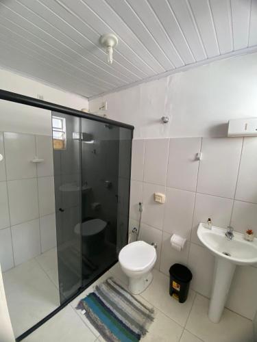 a bathroom with a shower and a toilet and a sink at Quarto Real - Centro Histórico in Diamantina