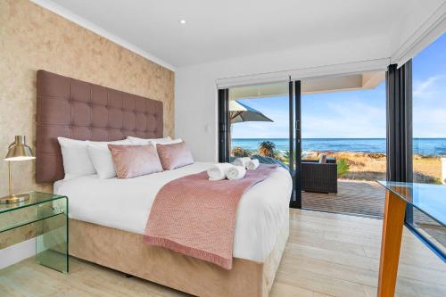 a bedroom with a bed with a view of the ocean at Villa View in Stompneusbaai