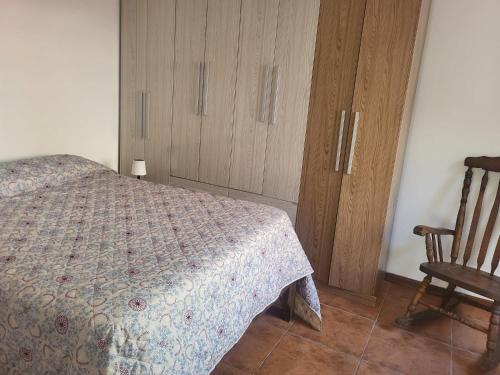 a bedroom with a bed and a wooden cabinet at La Pinta Càlida casa en Malvìn con cochera in Montevideo