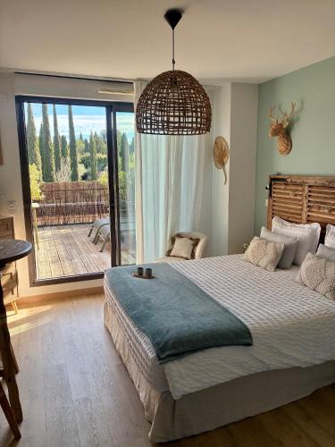 a bedroom with a large bed and a large window at Studio Nuitée en Provence 2 in Aix-en-Provence