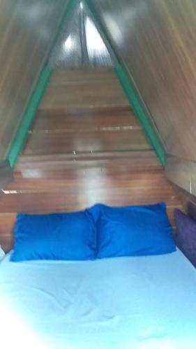 ein Bett in einem Zelt mit blauen Kissen in der Unterkunft Caveira in Mairiporã