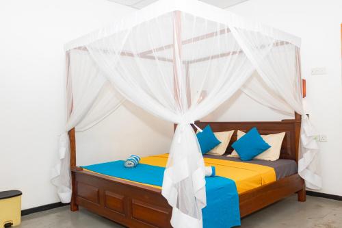a bedroom with a bed with a canopy at Blue Ocean - Private Villa 03 BR in Tangalle