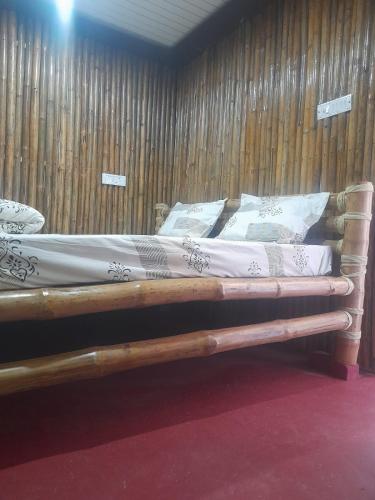 a bed in a room with wooden walls at BAGIYA Hut RESORT in Billi