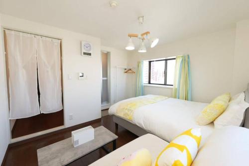a room with two beds and a couch and a window at sakura 601 in Tokyo