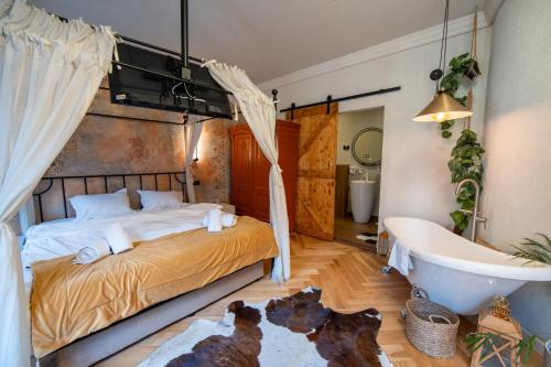 a bedroom with a bed and a bathtub and two dogs on a rug at Barrique Garden - Breakfast & Restaurant - Old Town -Officially classified guesthouse in Braşov