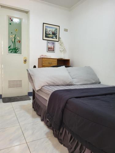 a bedroom with a bed and a table and a door at Mr B Guest House Room Rentals in San Fernando, Cebu in San Fernando