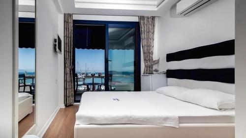 a bedroom with a white bed and a balcony at Urla Marin otel in İzmir