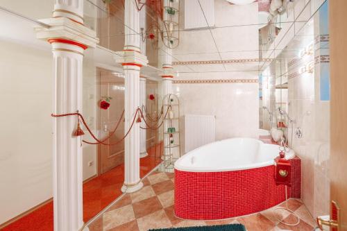 a white bathroom with a red tub in a room at König Ludwig Design Hotel NEU Zimmer mit Sauna oder Whirlpool, genug Parkplatz in Altötting