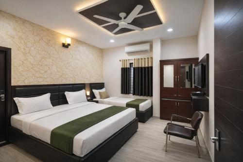 a hotel room with two beds and a tv at Hotel YO94 in Indore