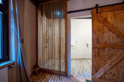 a sliding barn door in a room with a bed at Barrique Garden - Breakfast & Restaurant - Old Town -Officially classified guesthouse in Braşov