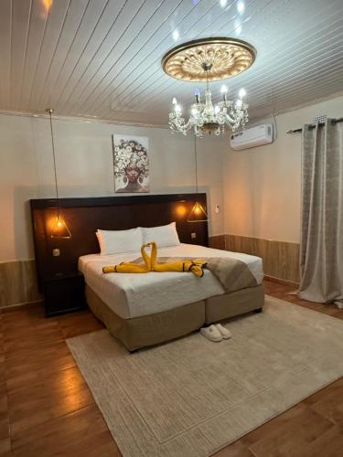 a bedroom with a large bed with a chandelier at Sazeesha Apartments in Ndola