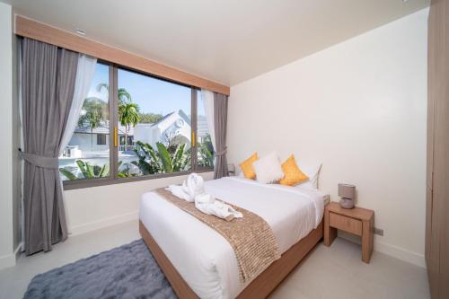 a bedroom with a bed and a large window at 竹光别院 Bamboo Radiance Villa in Ban Thalat Choeng Thale