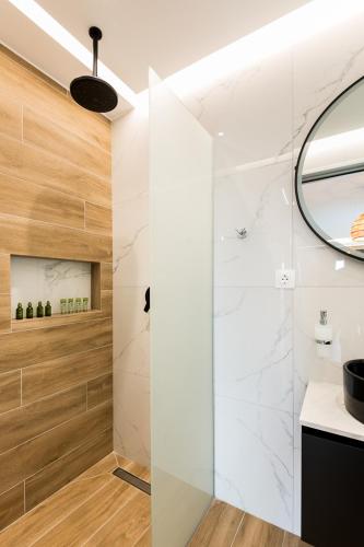 a bathroom with a shower and a mirror at Mulberry Suites in Paralia Dionysiou