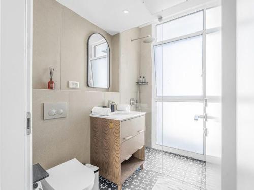 a bathroom with a sink and a toilet and a mirror at Redsearent suite with pool view 16 in Eilat