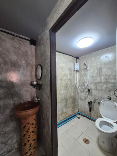a bathroom with a toilet and a shower at บ้านพักหลังวัดโลกโมฬี in Chiang Mai