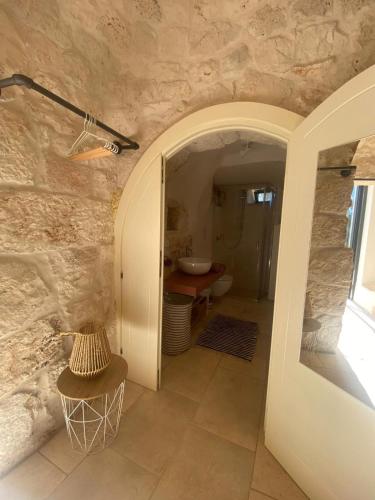 a stone bathroom with a sink and a toilet at Casina Fumarola in Ostuni