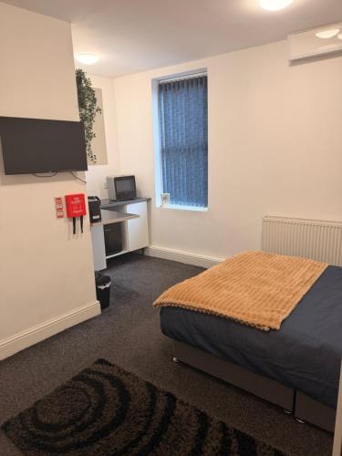 a bedroom with a bed and a flat screen tv at Your Cozy Colne Getaway Free parking and views in Colne