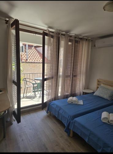 a bedroom with two beds and a balcony with a table at House Vodice in Vodice