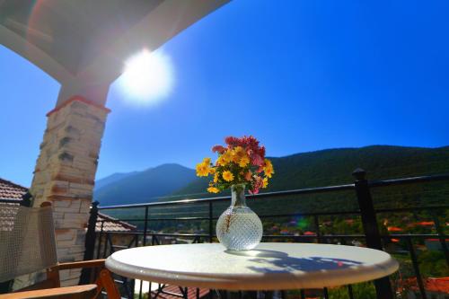 a vase with flowers on a table on a balcony at Artemis Traditional Guesthouse in Levidhion
