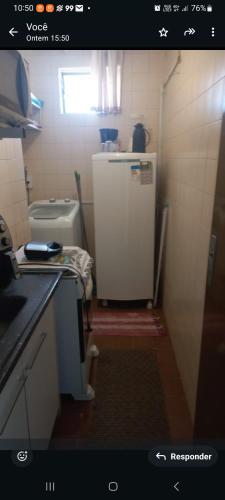 a small kitchen with a refrigerator and a toilet at no centro de Cuiabá aptº mobiliado in Cuiabá