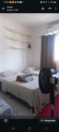 two beds in a room with a camera on the floor at no centro de Cuiabá aptº mobiliado in Cuiabá