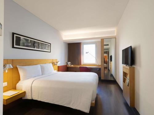 a hotel room with a bed and a television at ibis Chennai Sipcot - An Accor Brand in Chennai