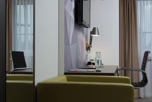a living room with a table and a green couch at Best Western Hotel Peine Salzgitter in Peine