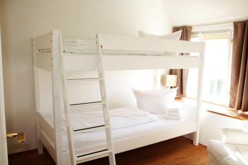 a white bunk bed with a ladder in a room at Stutenhof-Wohnung-06 in Keitum