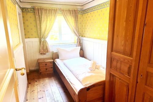 a small bed in a room with a window at Ferienhaus-„Alte-Schmiede“ in Westerland
