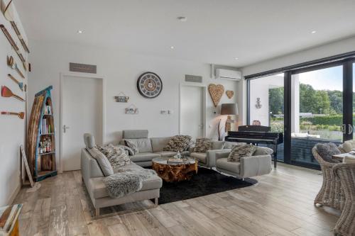 a living room with a couch and chairs and a piano at Harderwold Villa - 372 in Zeewolde