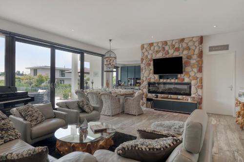 a living room with couches and a stone fireplace at Harderwold Villa - 372 in Zeewolde