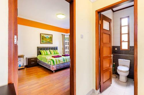 a bedroom with a bed and a toilet in a room at Dapur Caringin Tilu Villa in Arcamanik
